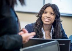 Student sitting behind laptop in classroom